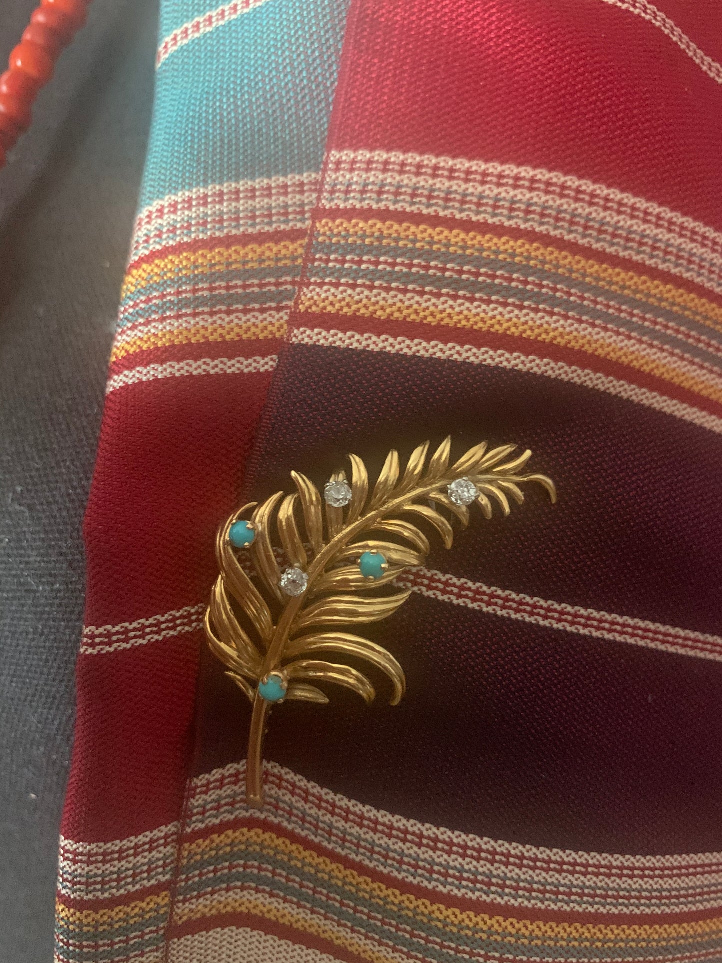 A 18kt gold brooch with turquoise and diamonds.