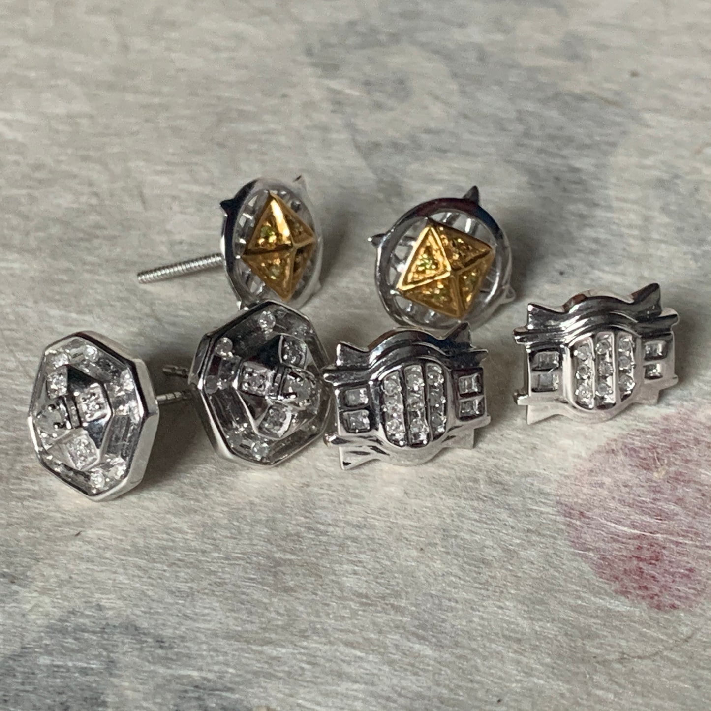 A set of three pairs of diamond ear studs in 10kt settings
