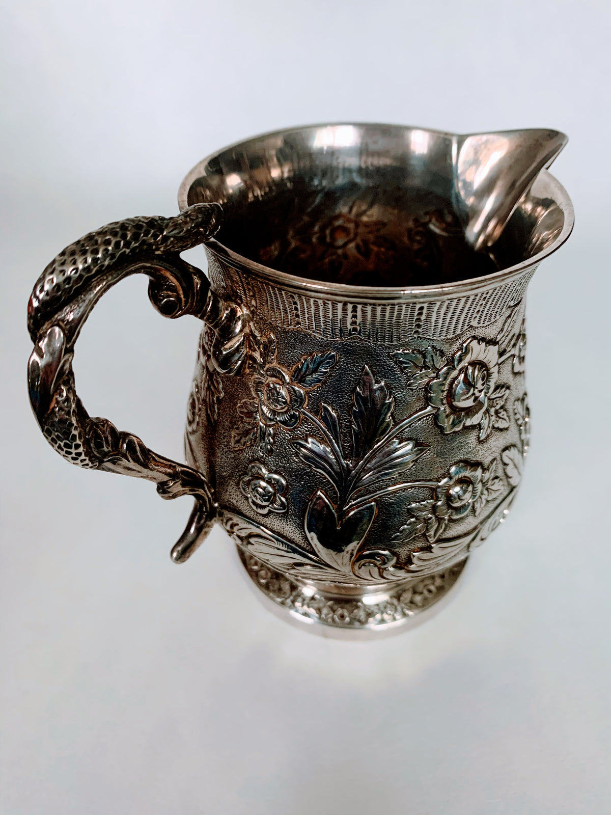 A silver creamer (roses)