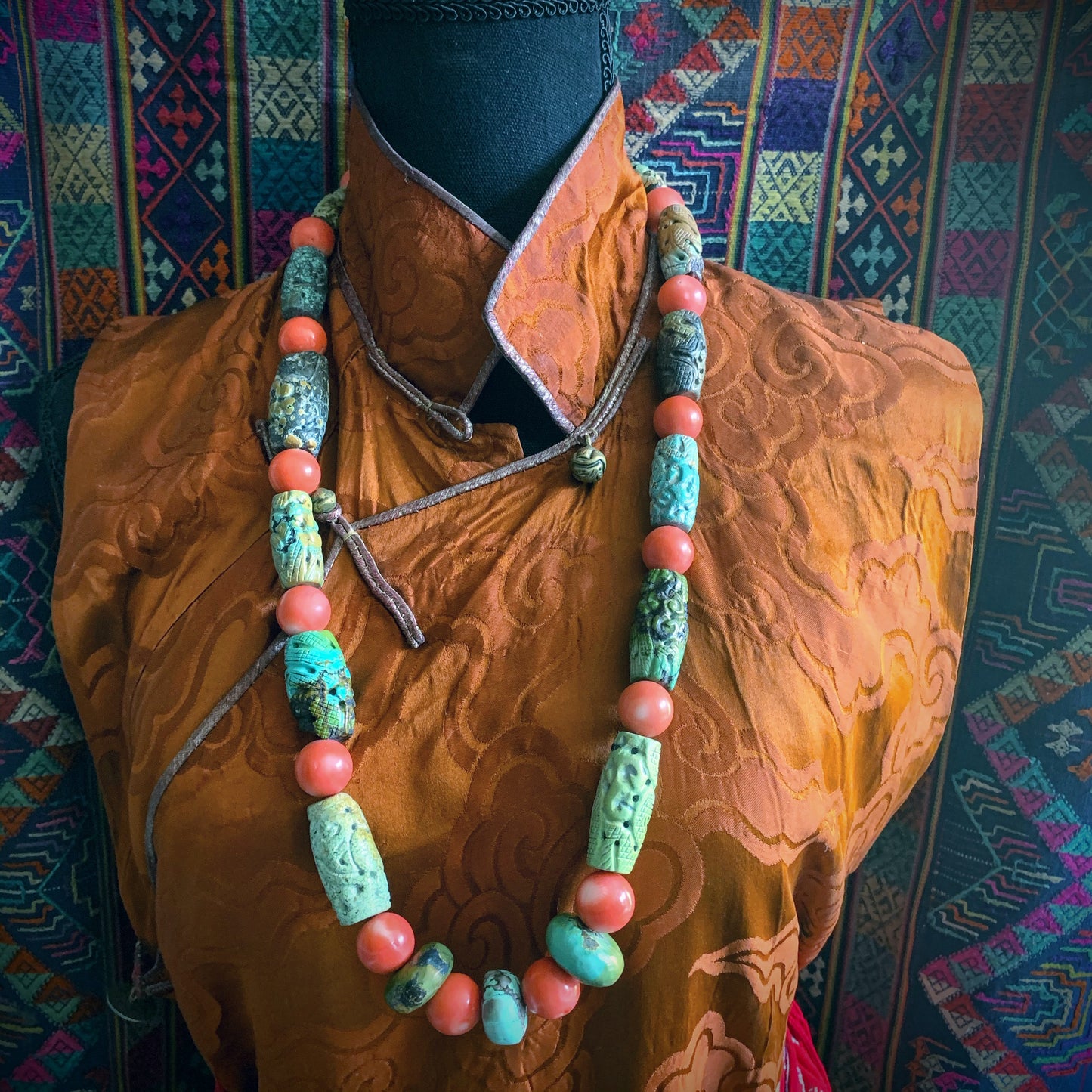 A necklace with antique carved turquoise and vintage coral beads