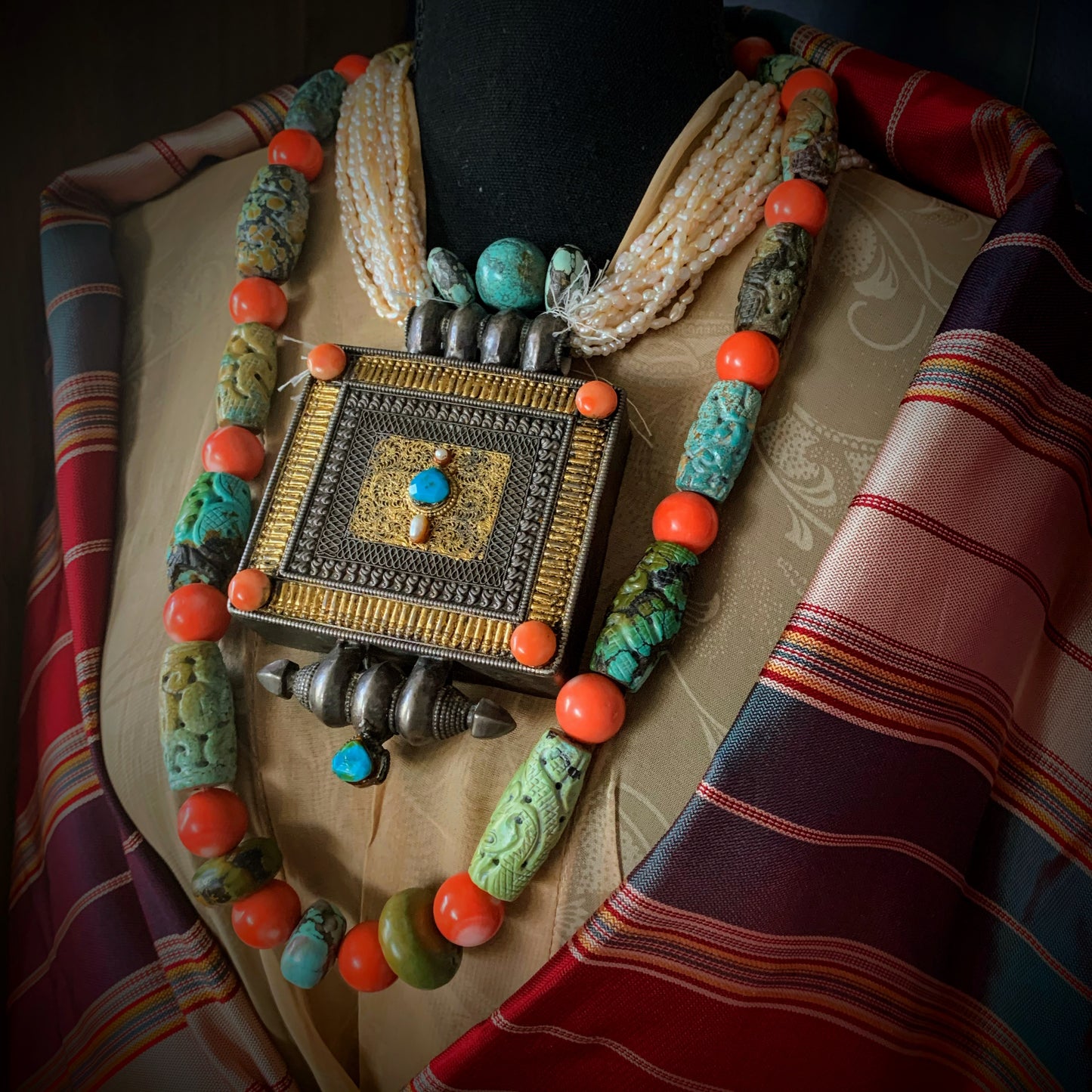 A necklace with antique carved turquoise and vintage coral beads