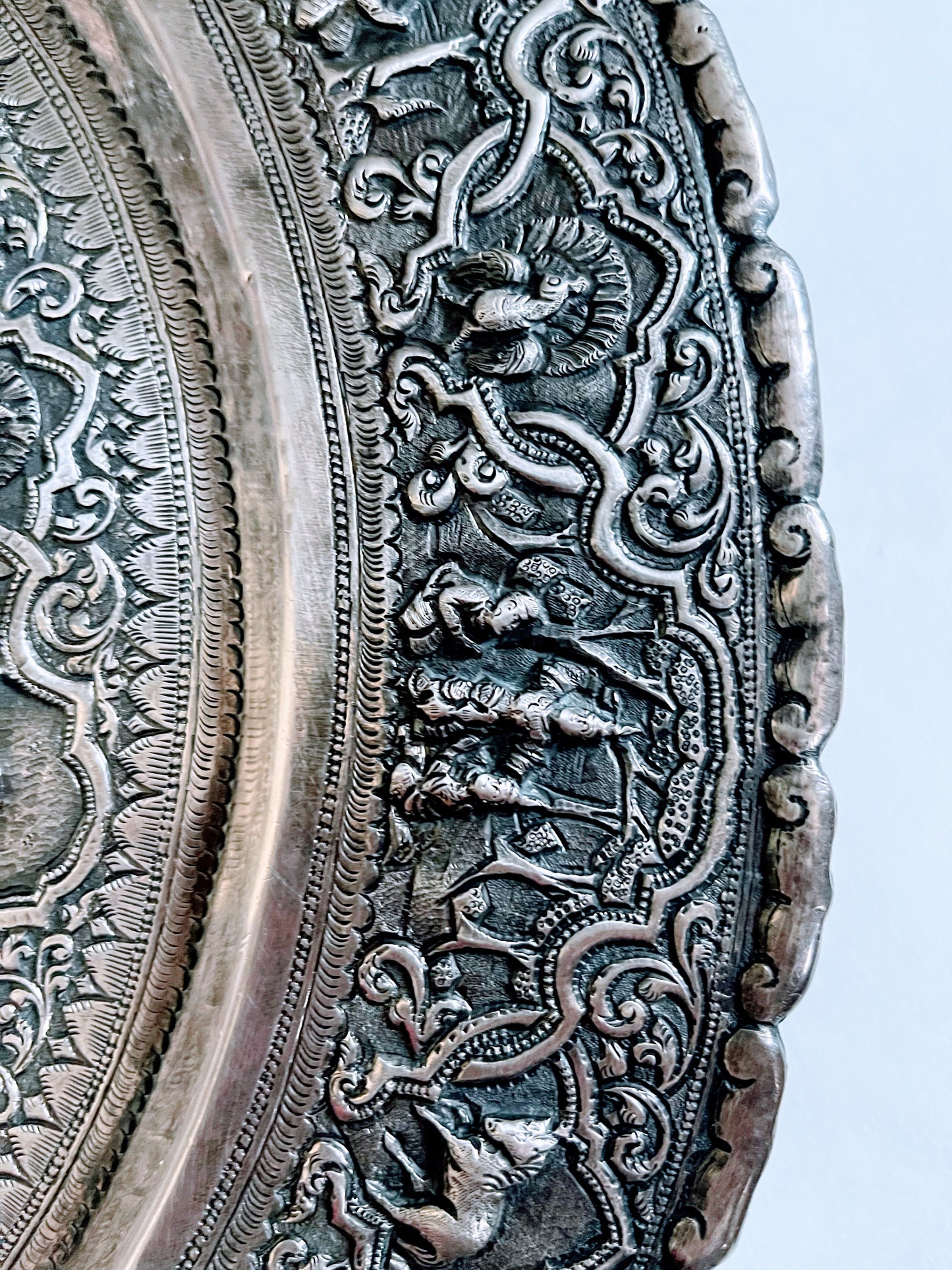 A Burmese antique elaborately carved circular tray and oval shaped jug with a pointed mug.