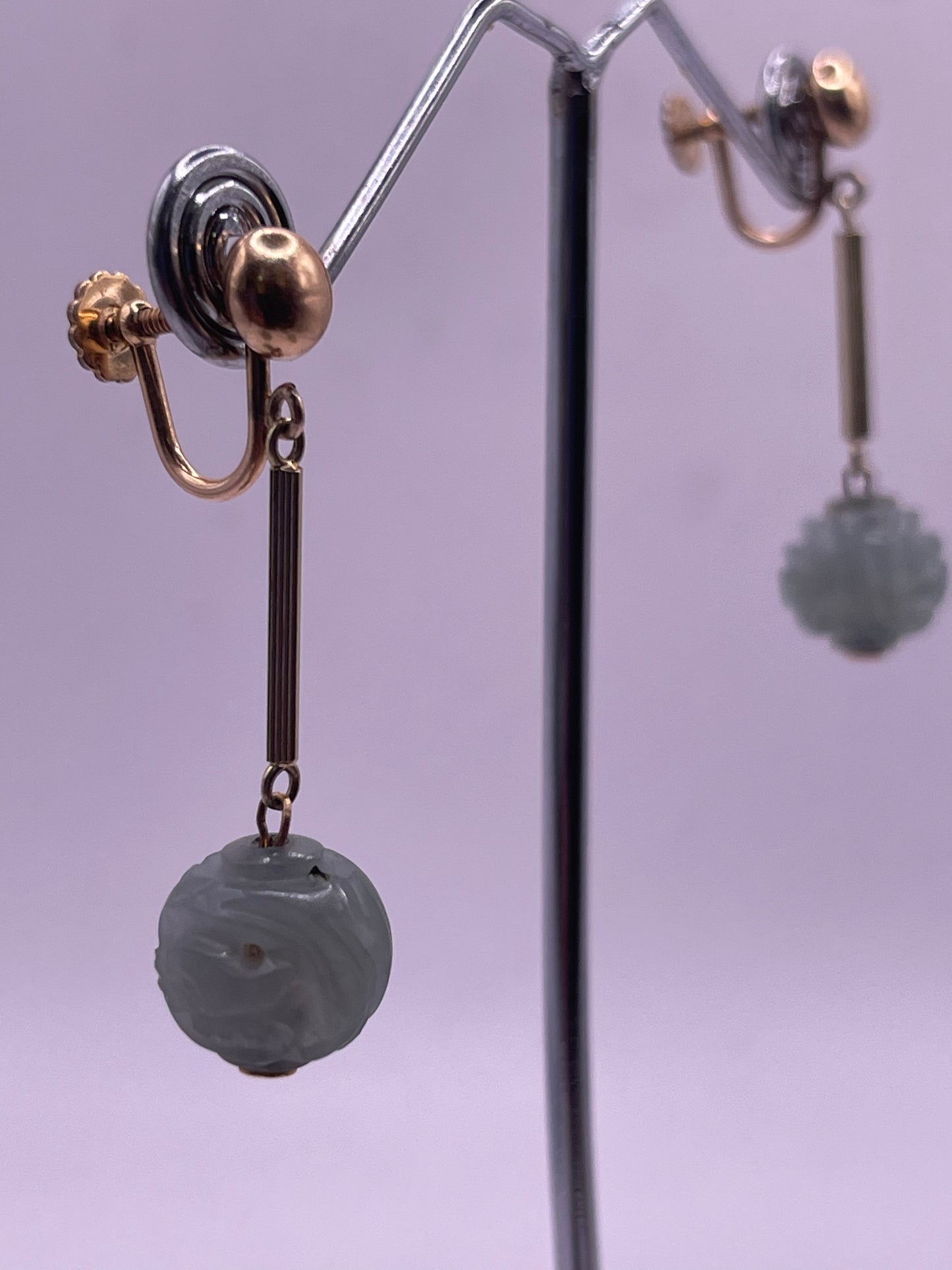 A pair of carved jade shou beads in a 14kt setting