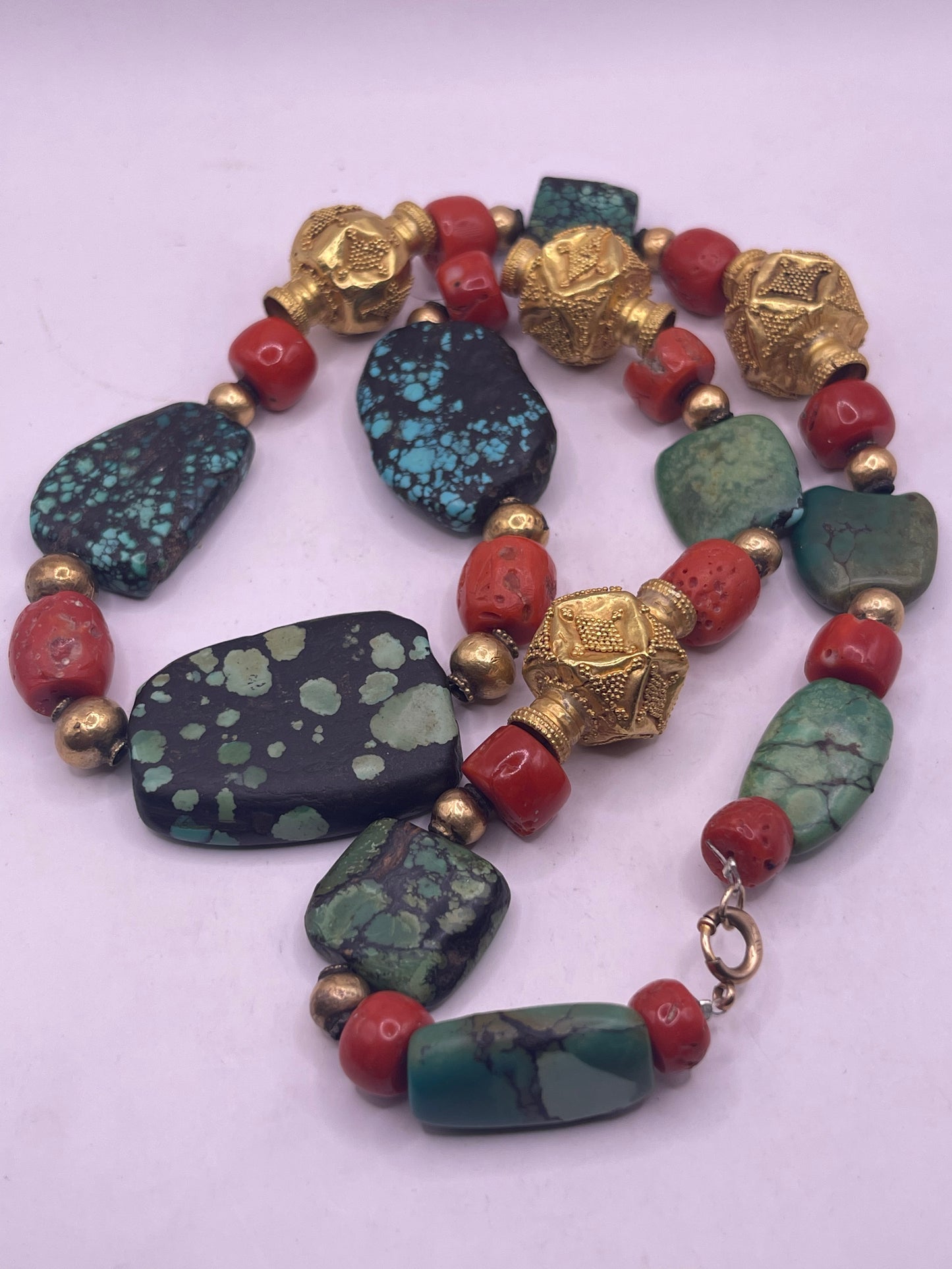 A necklace with antique Tibetan turquoise beads, coral beads and gold beads