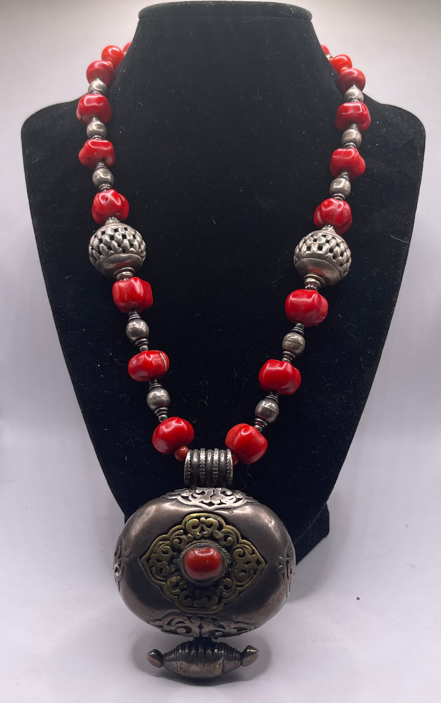Antique Tibetan coral ghau pendant with a coral and silver necklace