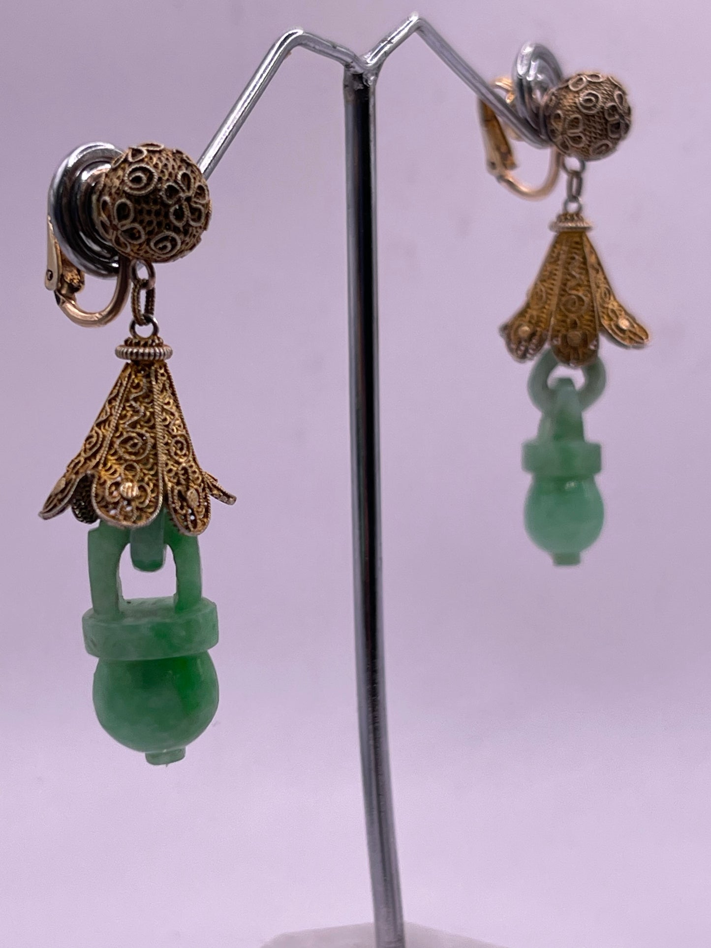 A pair of carved jade earrings in a gilded silver setting