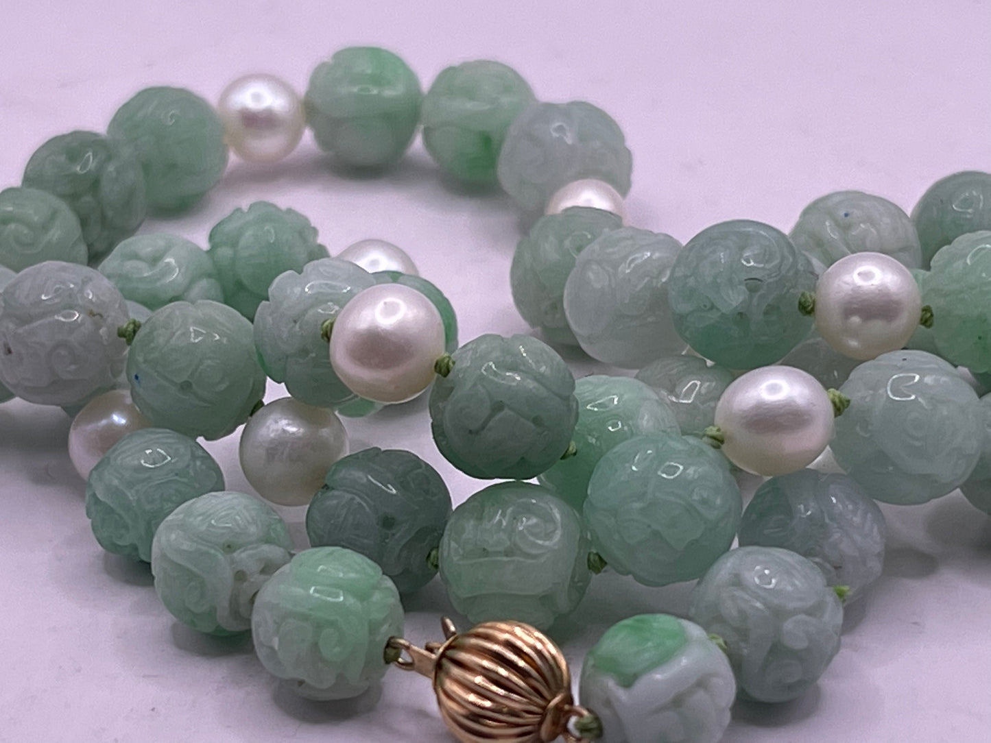 A necklace with vintage carved jade shou beads and pearls