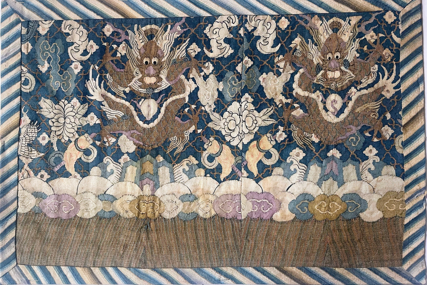 An antique framed Chinese silk kesi of a pair of dragons