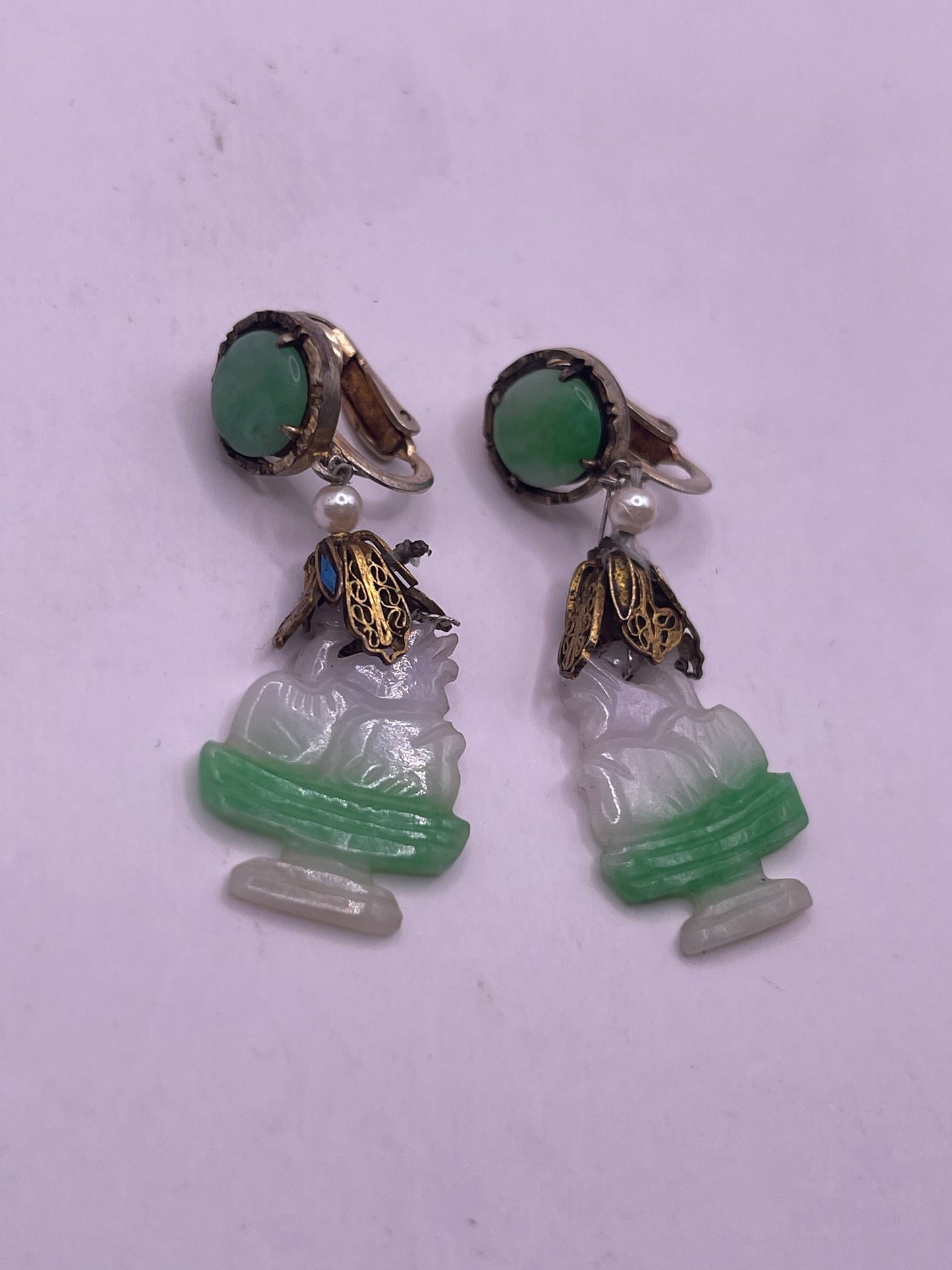 A pair of carved jade earrings in a gilded silver setting