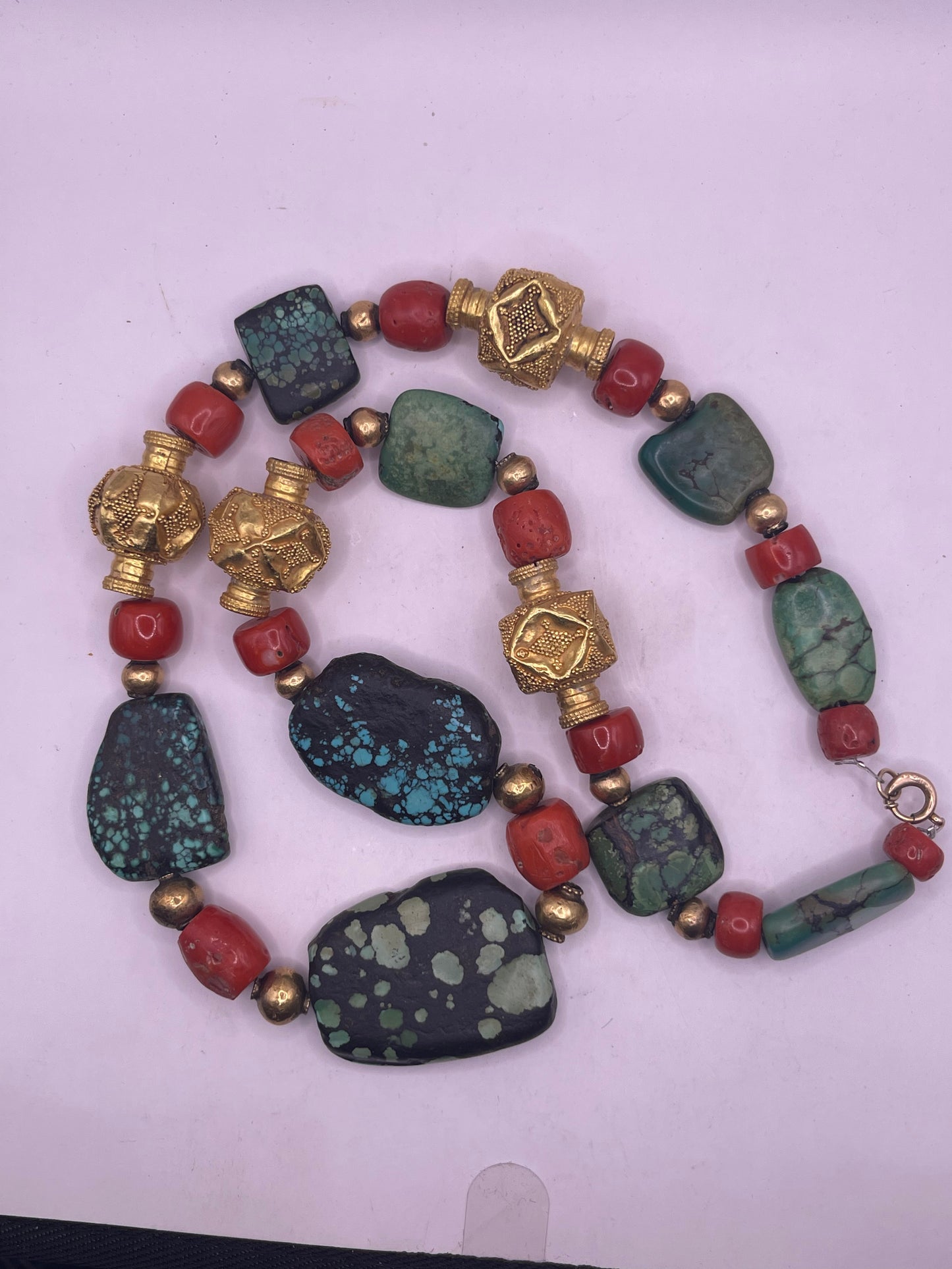 A necklace with antique Tibetan turquoise beads, coral beads and gold beads