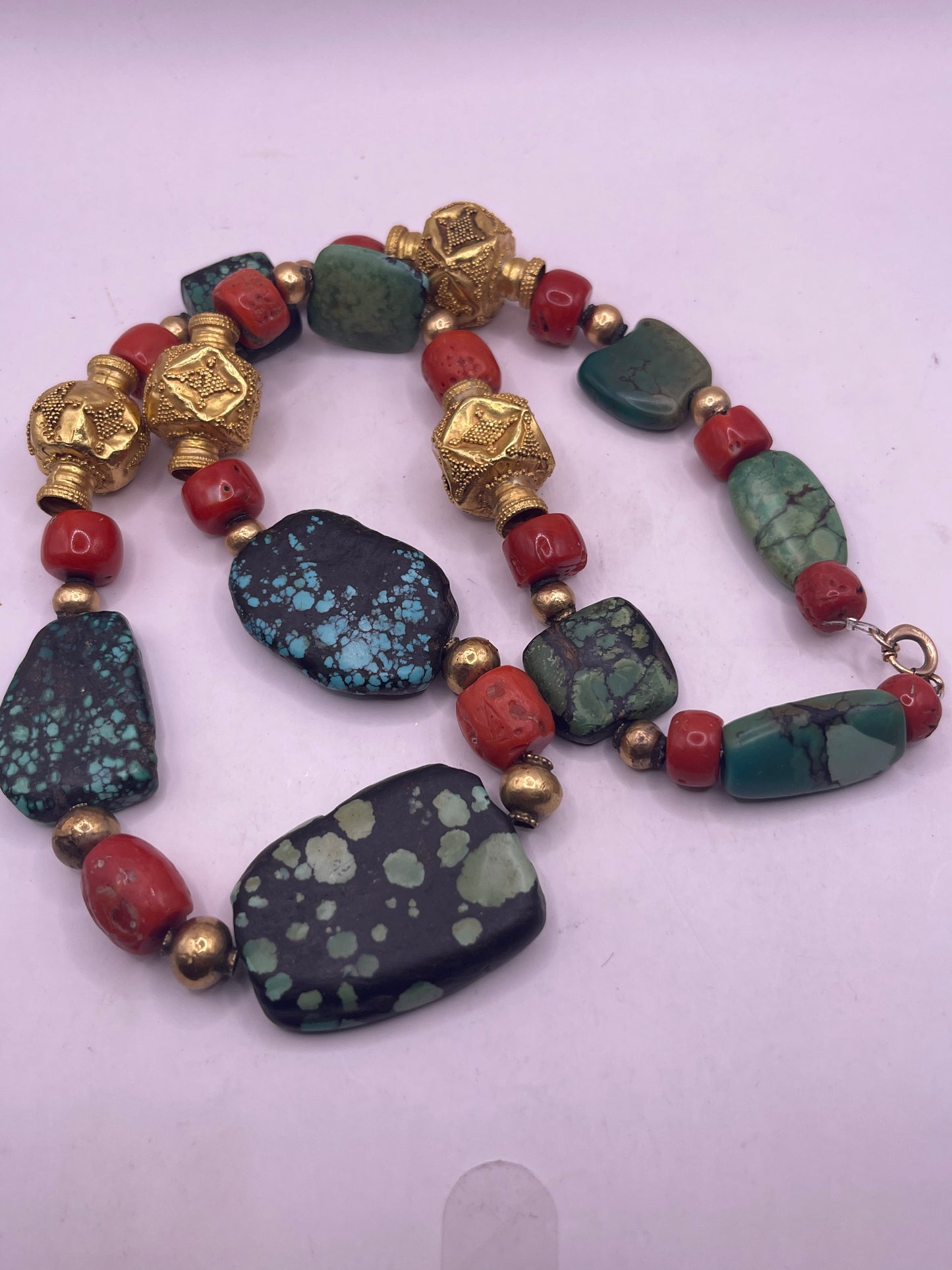 A necklace with antique Tibetan turquoise beads, coral beads and gold beads