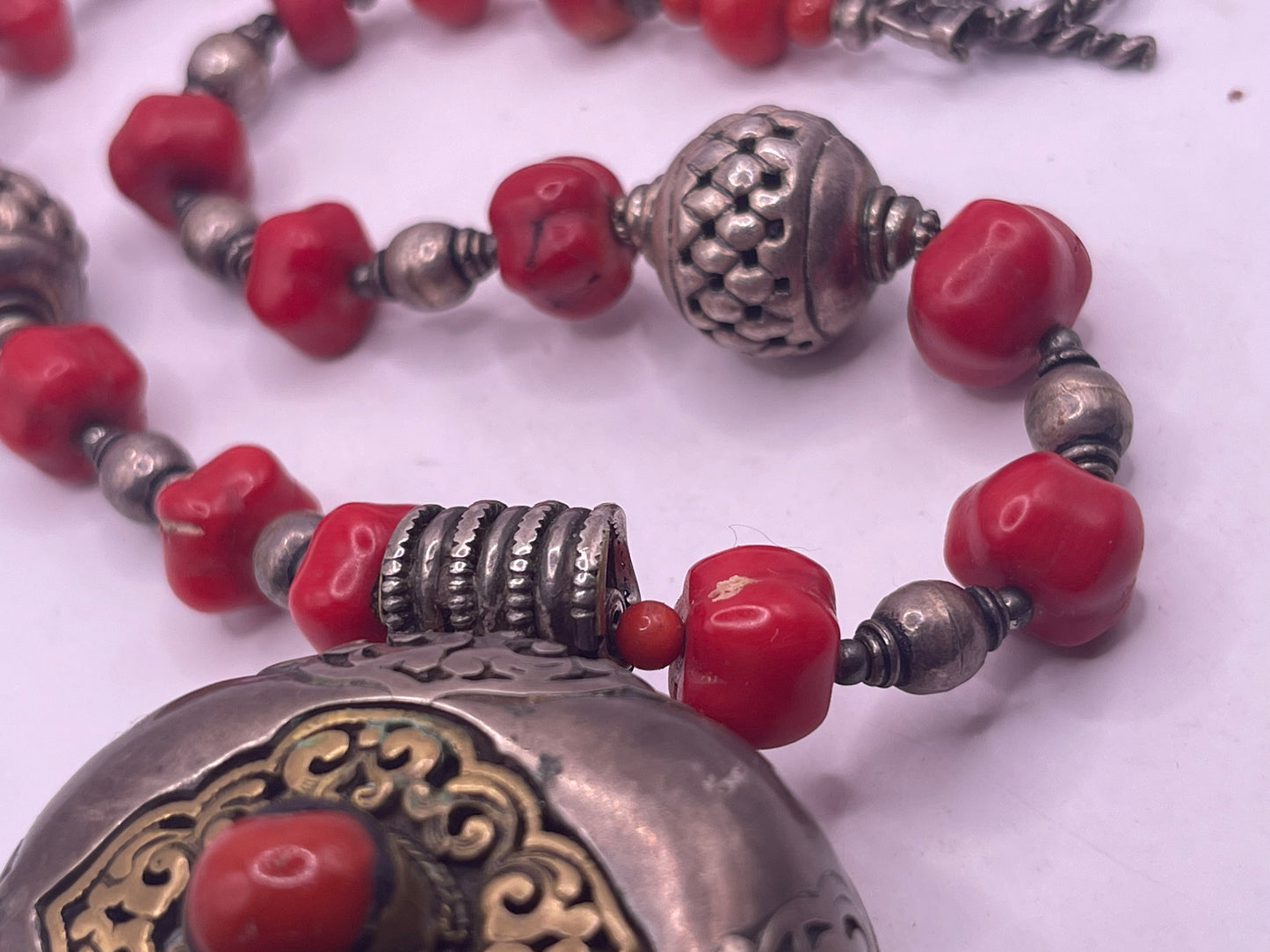 Antique Tibetan coral ghau pendant with a coral and silver necklace