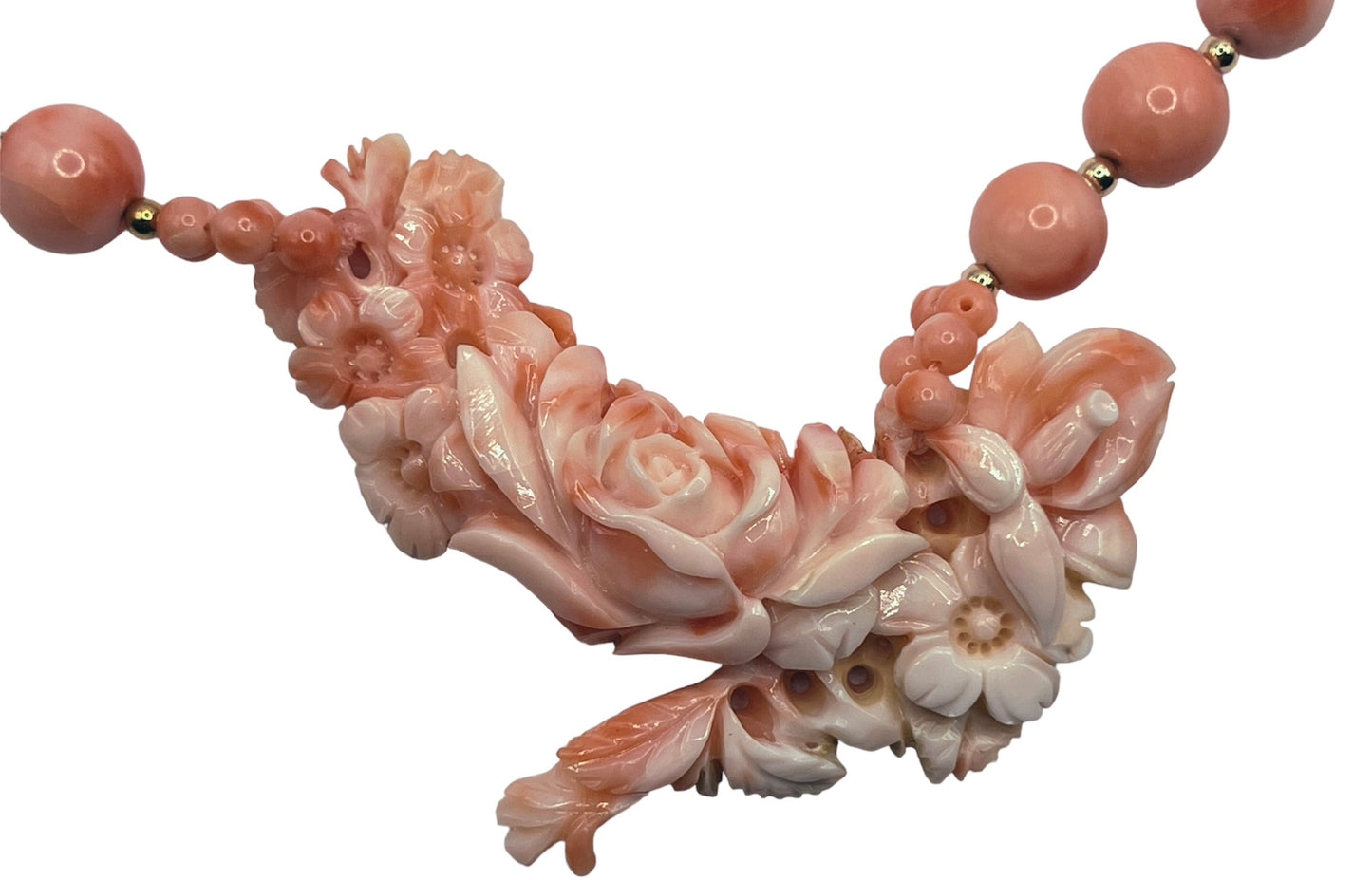 A coral necklace with coral beads and a carved coral pendant