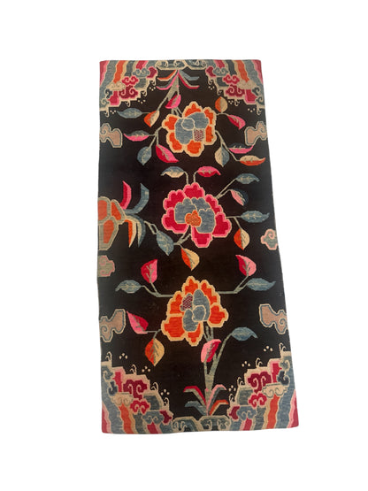 An early 20th C., antique black Tibetan with floral motif rug