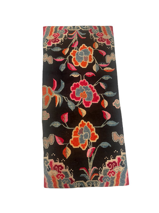 An early 20th C., antique black Tibetan with floral motif rug