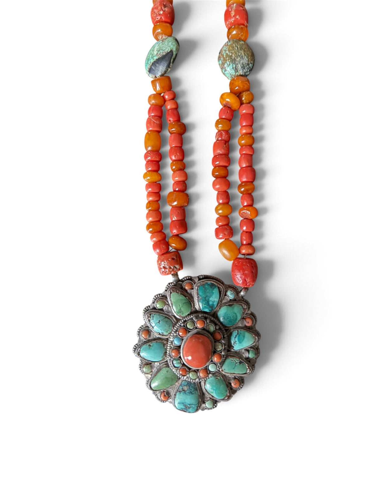Necklace with coral, amber and turquoise beads, and a circular silver pendant with coral and turquoise cabochons