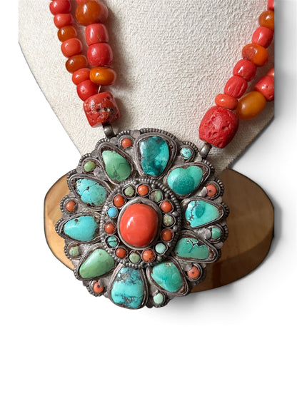 Necklace with coral, amber and turquoise beads, and a circular silver pendant with coral and turquoise cabochons