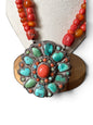 Necklace with coral, amber and turquoise beads, and a circular silver pendant with coral and turquoise cabochons