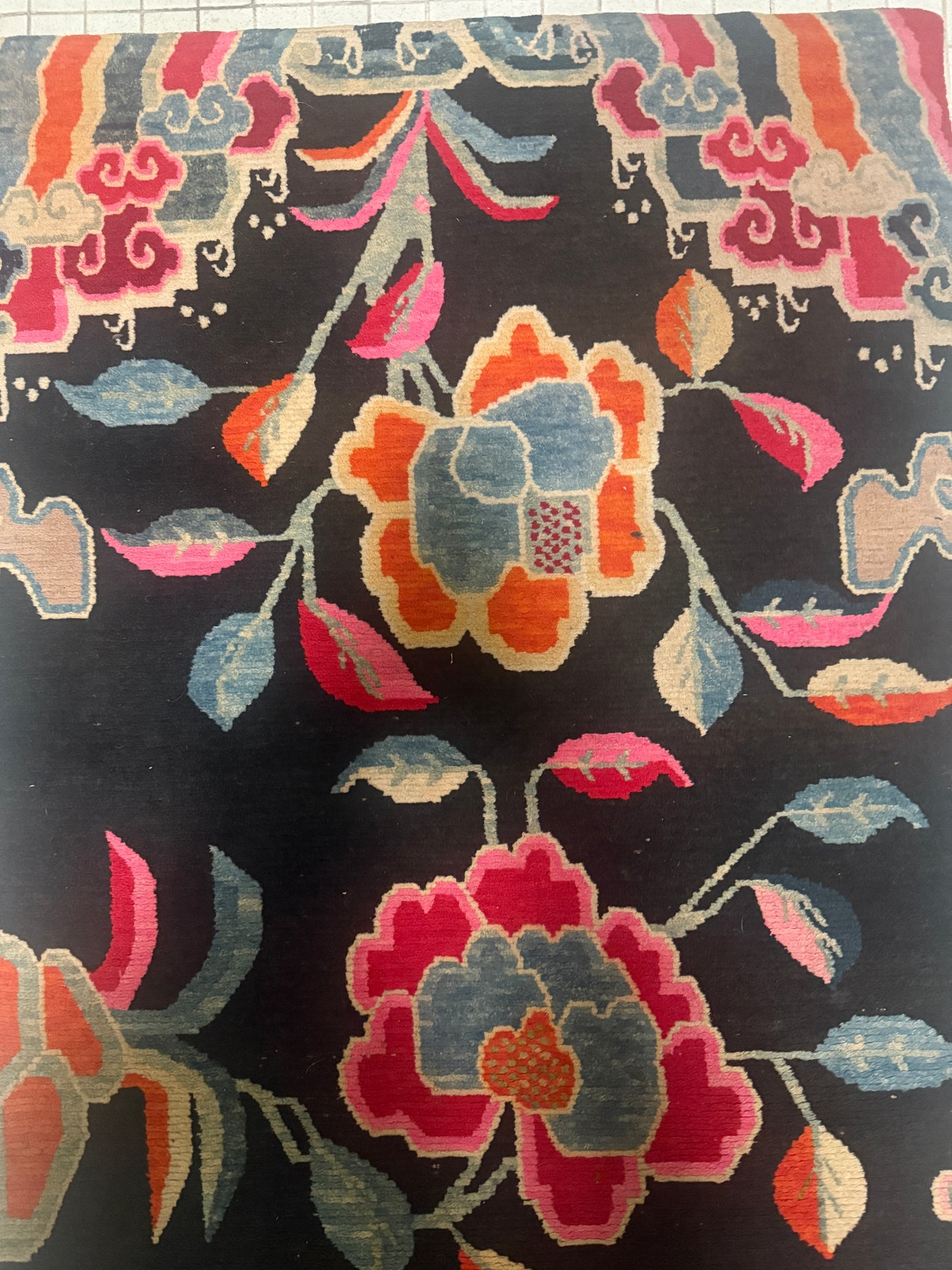 An early 20th C., antique black Tibetan with floral motif rug