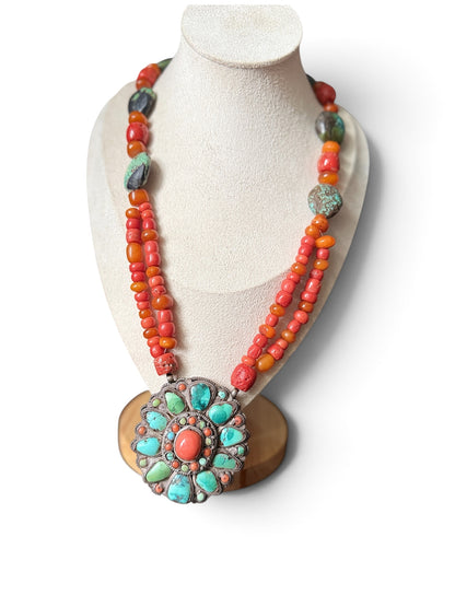 Necklace with coral, amber and turquoise beads, and a circular silver pendant with coral and turquoise cabochons