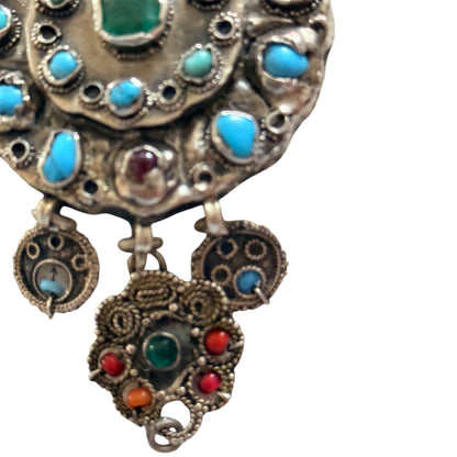 A silver antique turban brooch with turquoise, ruby and emeralds