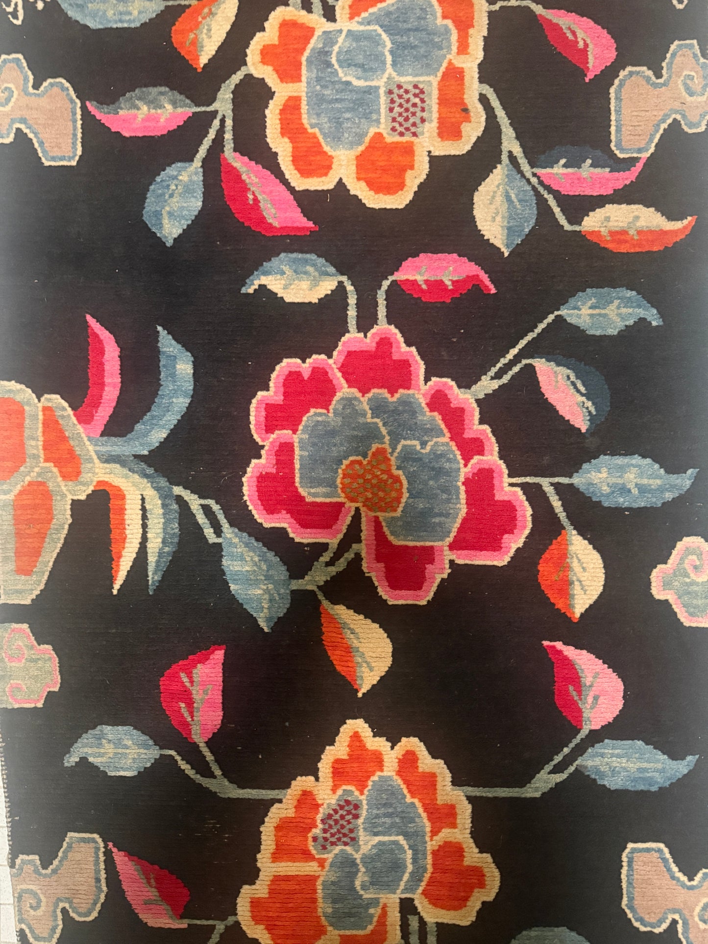An early 20th C., antique black Tibetan with floral motif rug