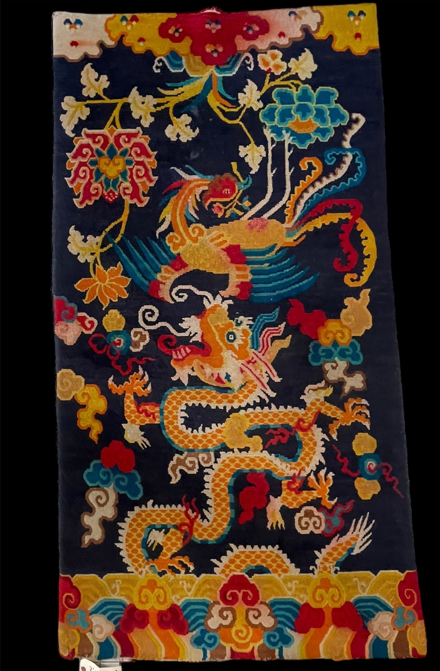 A vintage Tibetan rug featuring a dragon and phoenix