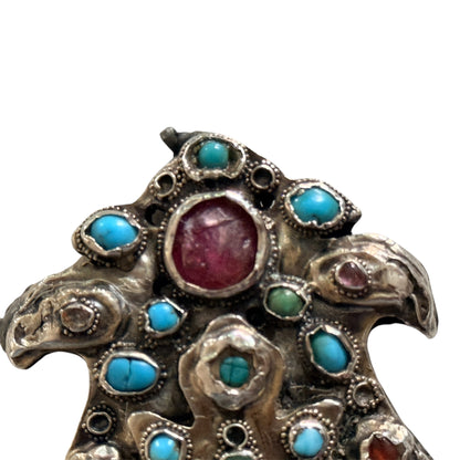 A silver antique turban brooch with turquoise, ruby and emeralds