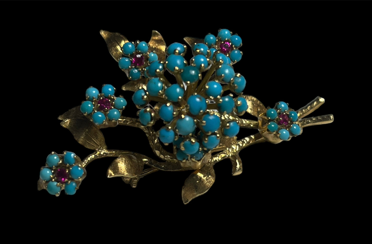 A 14k gold brooch with turquoise and ruby stones