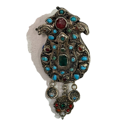 A silver antique turban brooch with turquoise, ruby and emeralds