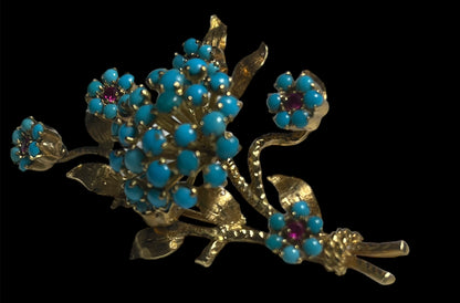 A 14k gold brooch with turquoise and ruby stones