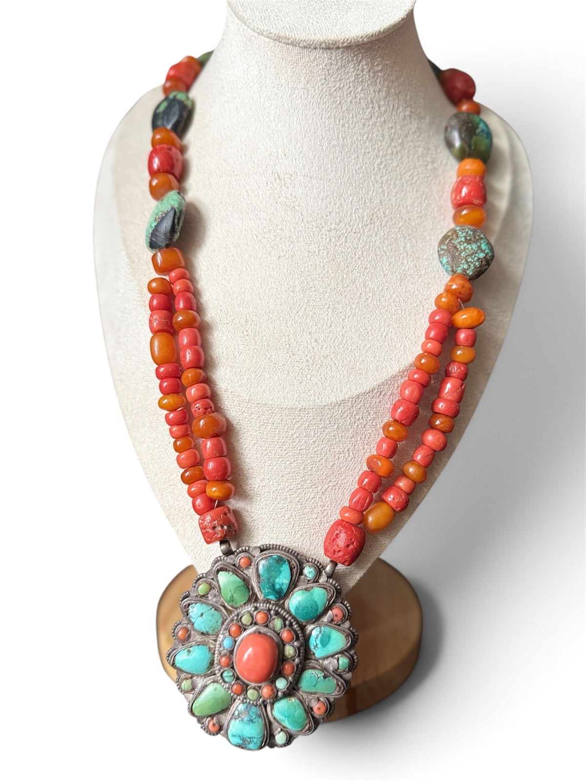 Necklace with coral, amber and turquoise beads, and a circular silver pendant with coral and turquoise cabochons