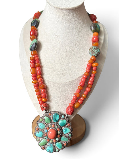 Necklace with coral, amber and turquoise beads, and a circular silver pendant with coral and turquoise cabochons