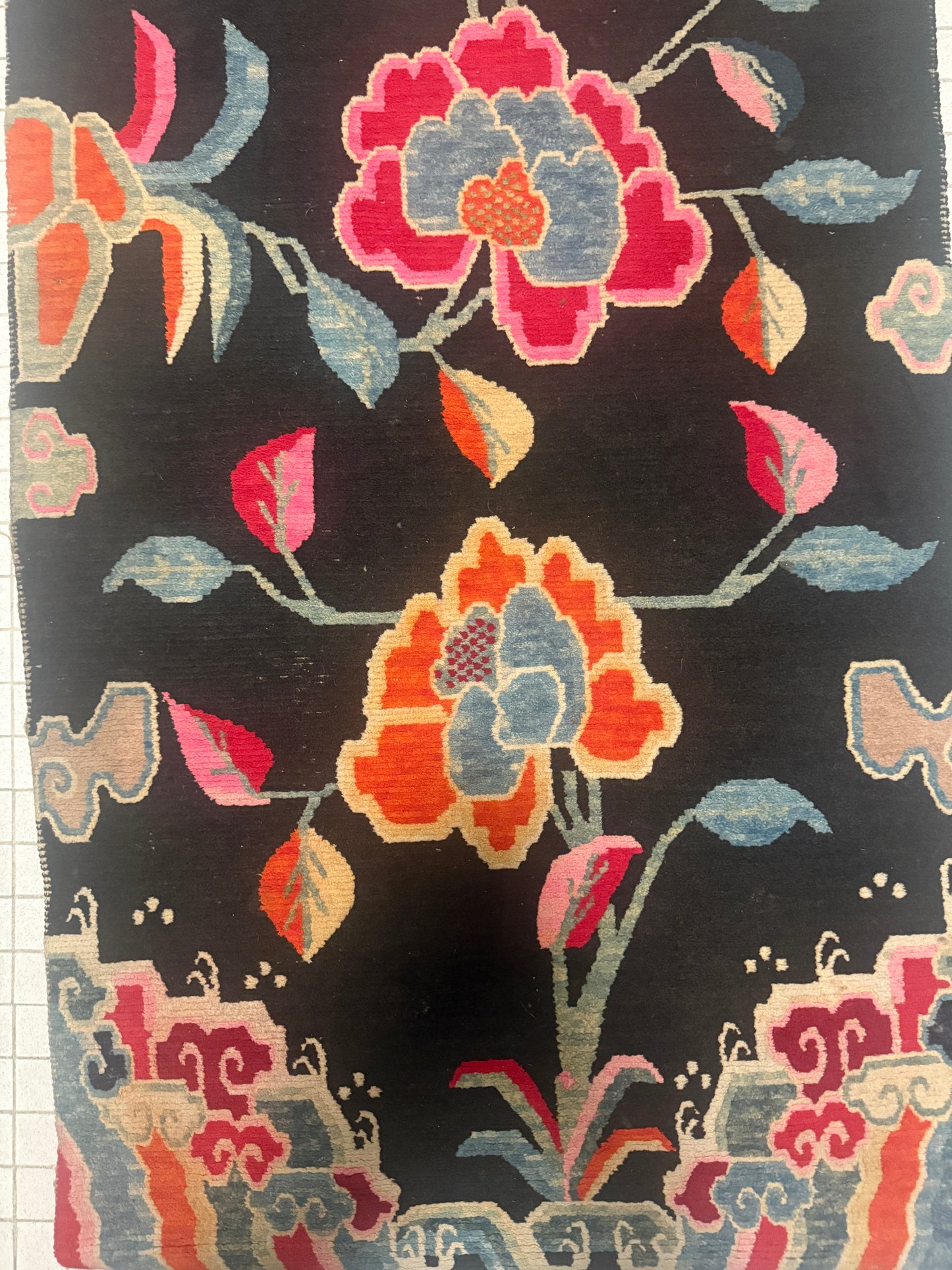 An early 20th C., antique black Tibetan with floral motif rug