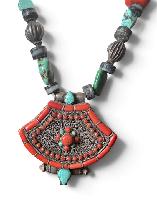 A vintage Tibetan silver ghau with a necklace with assorted beads