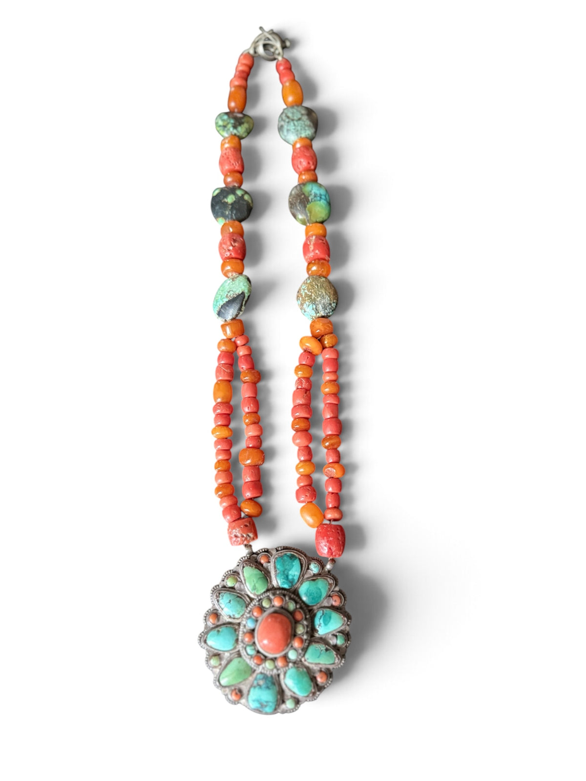 Necklace with coral, amber and turquoise beads, and a circular silver pendant with coral and turquoise cabochons