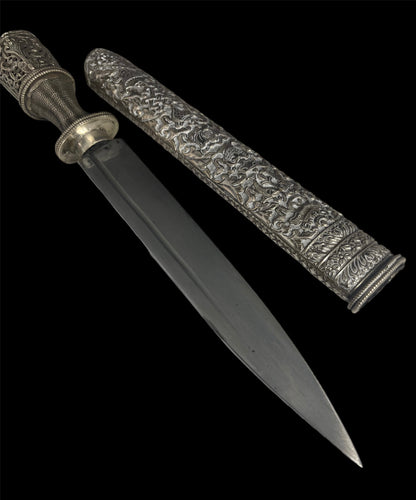 An antique Tibetan dagger with a carved silver sheath