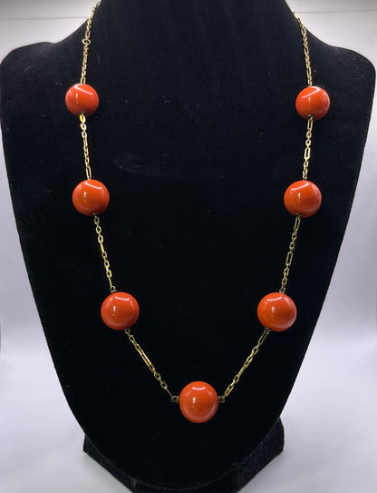 A necklace with coral beads on a 14kt chain