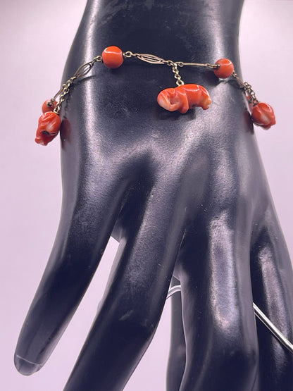 An antique coral bracelet with coral beads and carved coral elephant charms