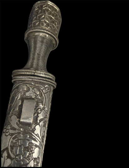An antique Tibetan dagger with a carved silver sheath