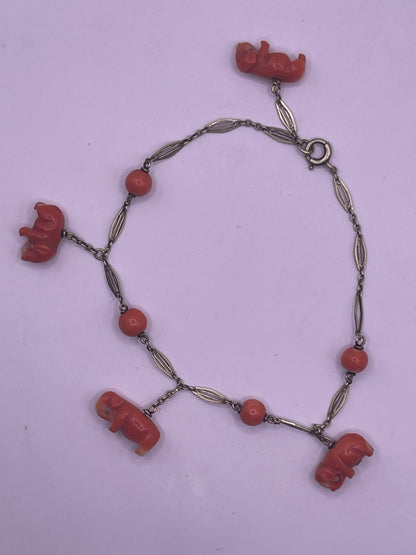 An antique coral bracelet with coral beads and carved coral elephant charms