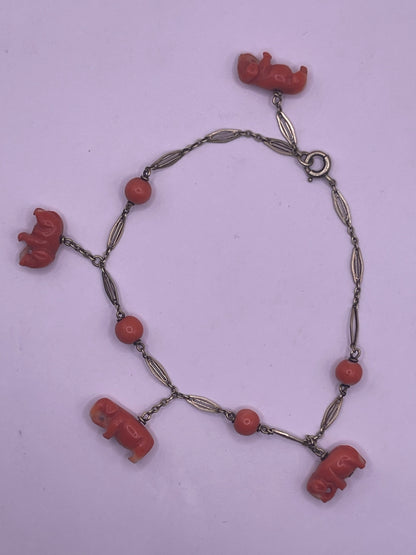 An antique coral bracelet with coral beads and carved coral elephant charms