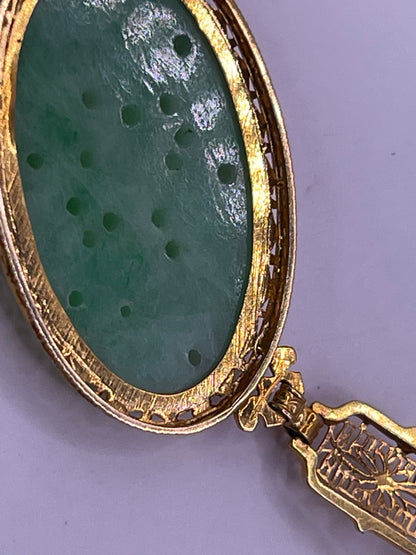 A vintage Art Deco style necklace with a antique apple green jade carved plaque in a 14kt filigree setting