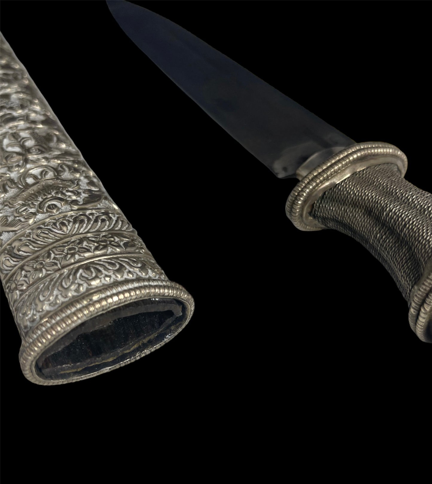 An antique Tibetan dagger with a carved silver sheath