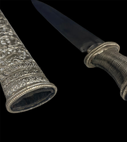 An antique Tibetan dagger with a carved silver sheath