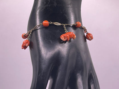 An antique coral bracelet with coral beads and carved coral elephant charms
