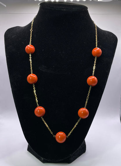 A necklace with coral beads on a 14kt chain