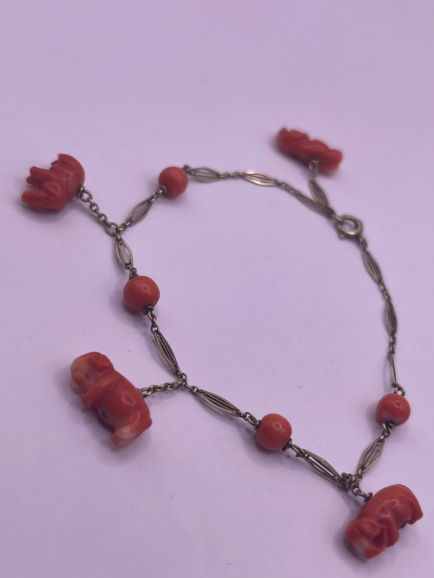 An antique coral bracelet with coral beads and carved coral elephant charms