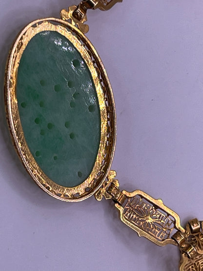 A vintage Art Deco style necklace with a antique apple green jade carved plaque in a 14kt filigree setting