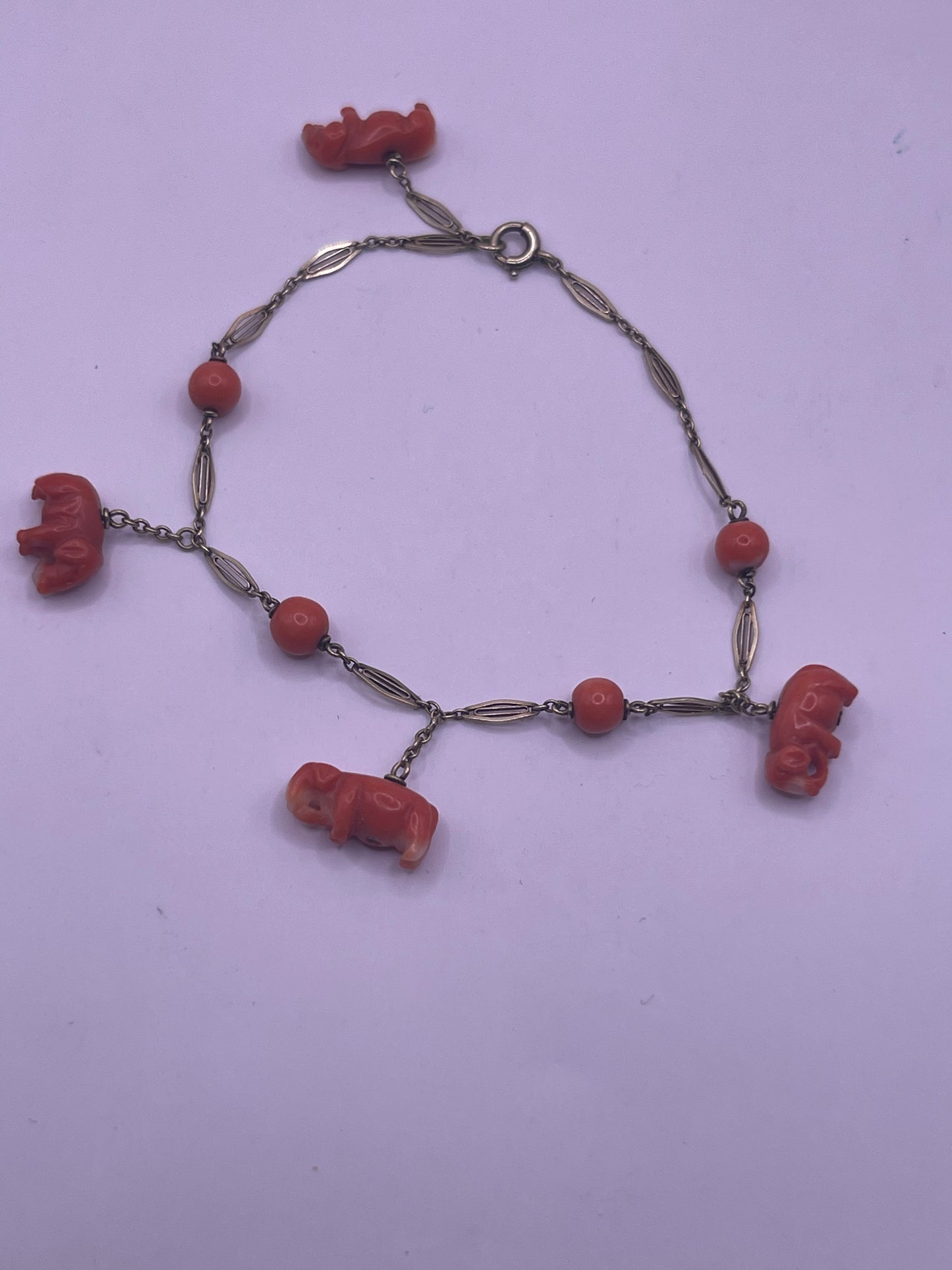 An antique coral bracelet with coral beads and carved coral elephant charms